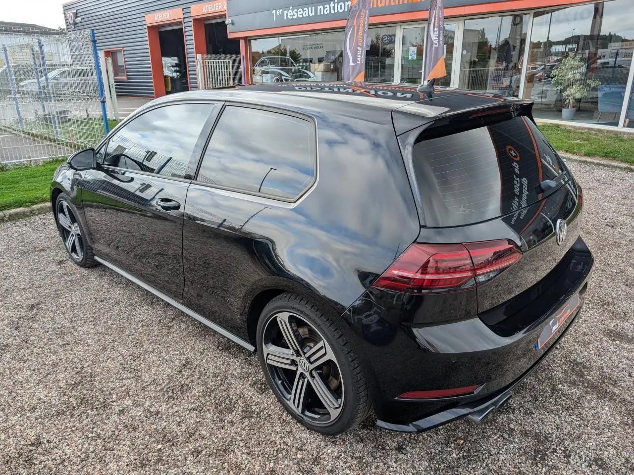 Vue 3/4 arrière droite d'une Volkswagen Golf noire 2017 avec jantes alliage 18 pouces et vitres teintées.