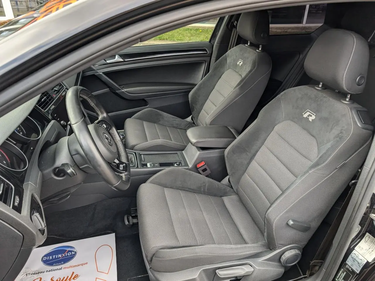 Vue intérieure côté conducteur d'une Volkswagen Golf R 2017 noire avec sièges sport en tissu et alcantara siglés "R"