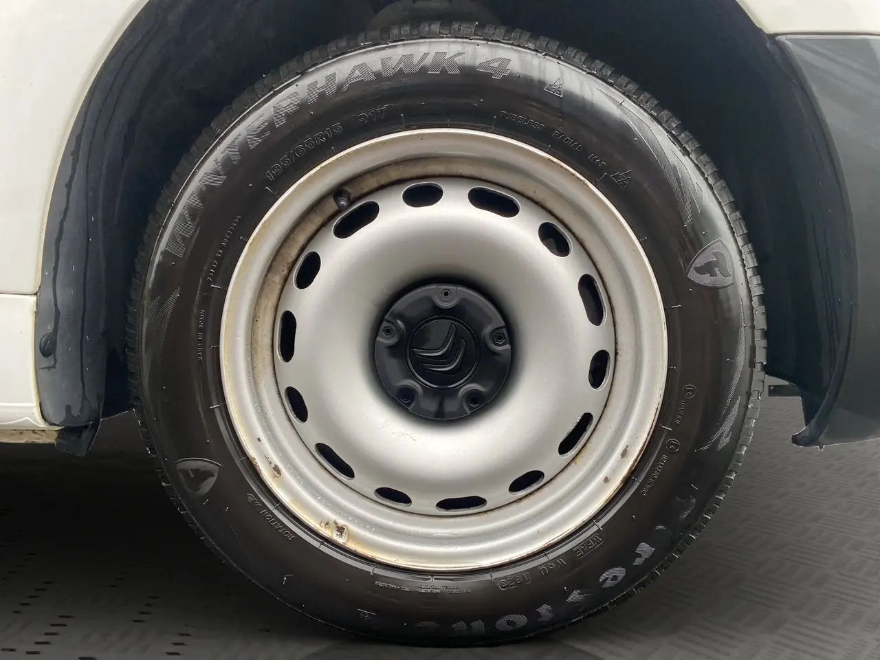 Gros plan sur la roue avant droite blanche du Citroën Berlingo 2018 avec jante acier et pneu Firestone Winterhawk.