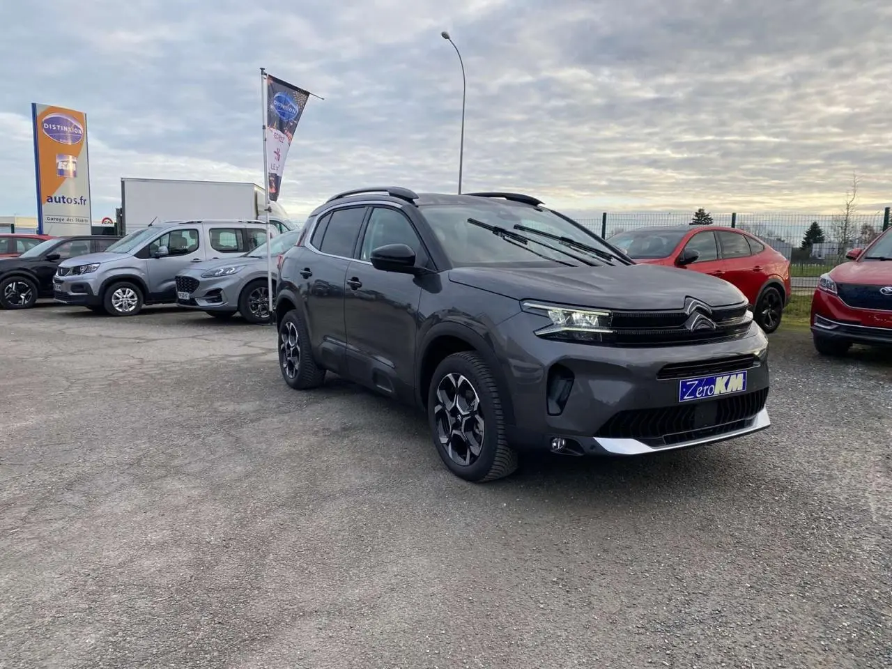 Citroën C5 Aircross gris platinium en 3/4 avant droit, avec jantes alliage bi-ton et projecteurs LED allumés.