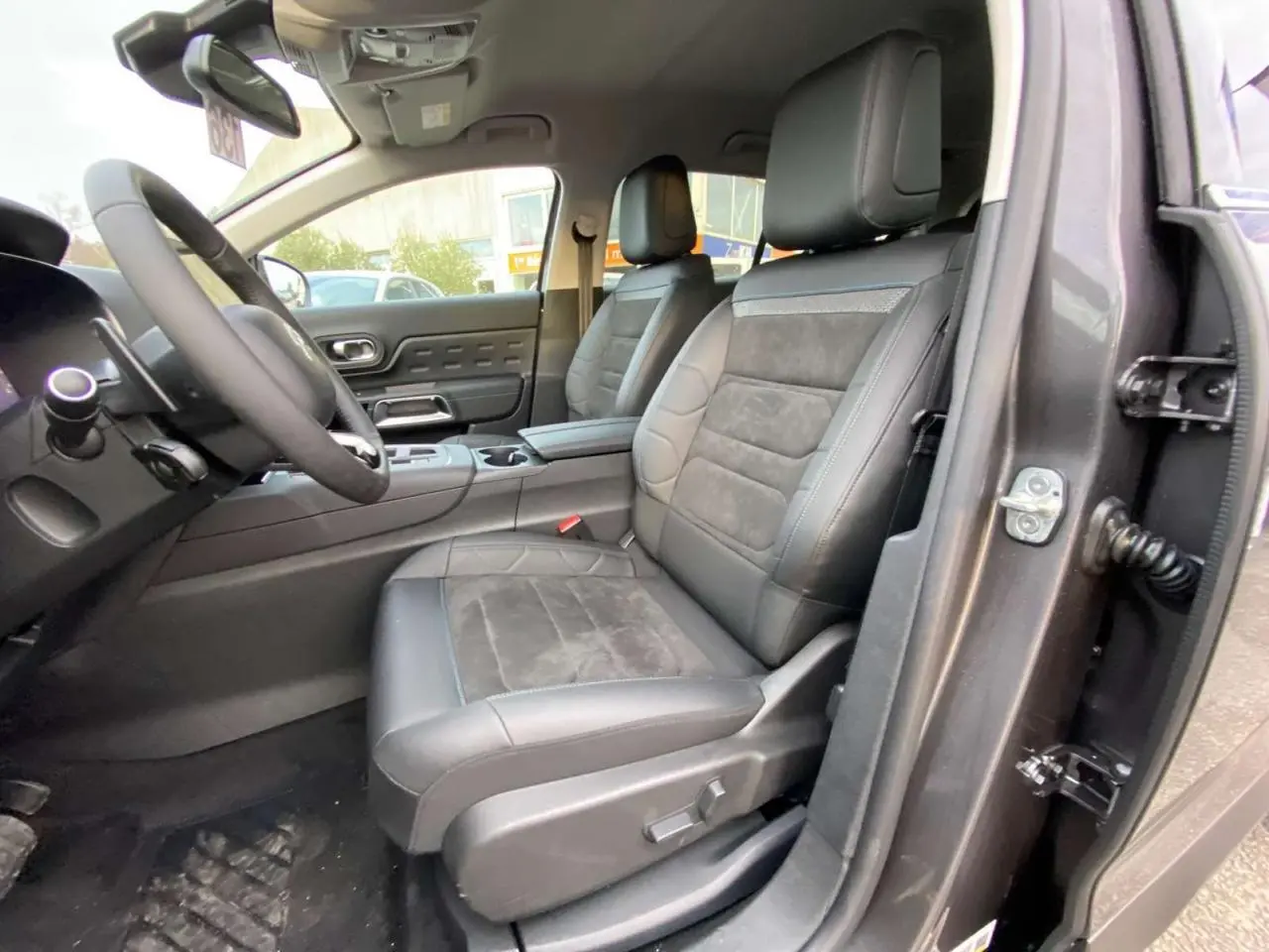 Vue intérieure côté conducteur du Citroën C5 Aircross 2025 gris platinium, sièges cuir et alcantara avec console centrale visible.