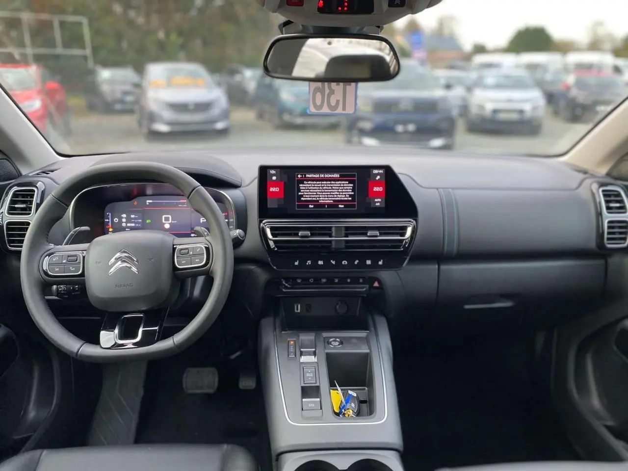 Vue intérieure avant du Citroën C5 Aircross gris platinium, tableau de bord moderne avec écran tactile 10 pouces et volant multifonction.
