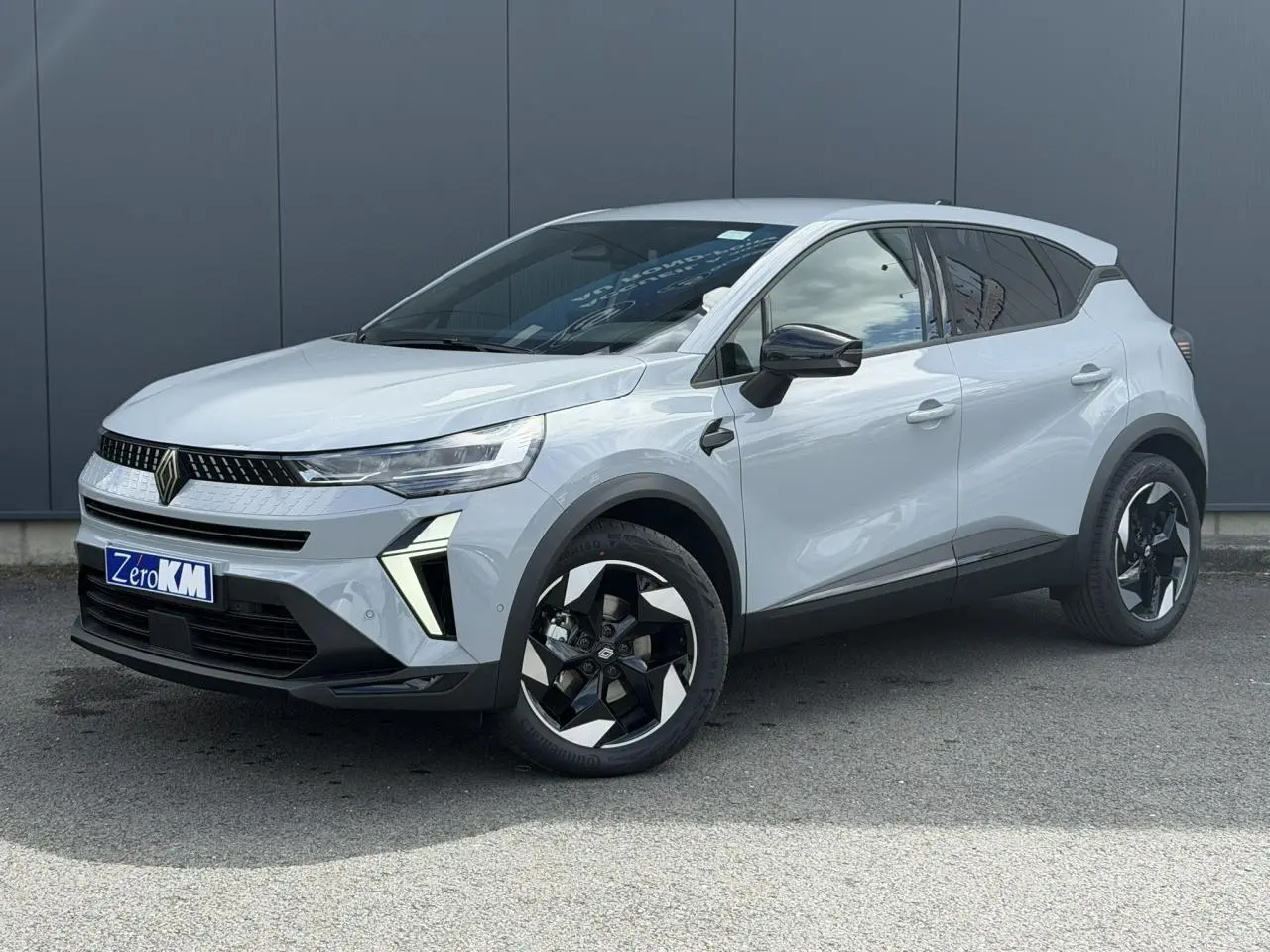 Renault Captur 2026 gris Rafale en 3/4 avant droit, avec jantes noires et détails modernes contrastés.