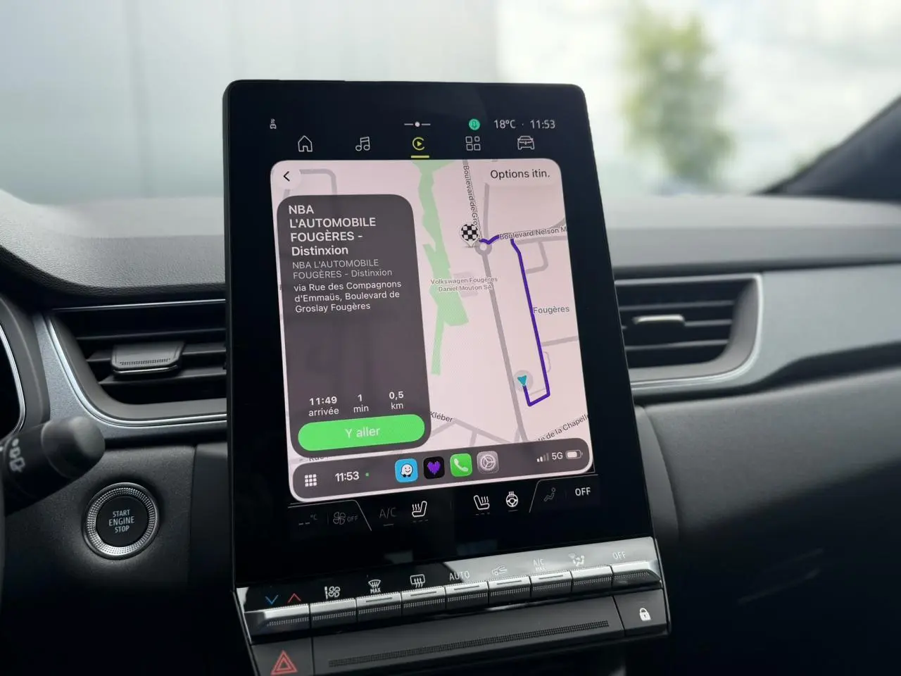 Vue intérieure centrée sur l'écran tactile vertical du tableau de bord du Renault Captur gris Rafale, avec navigation affichée.