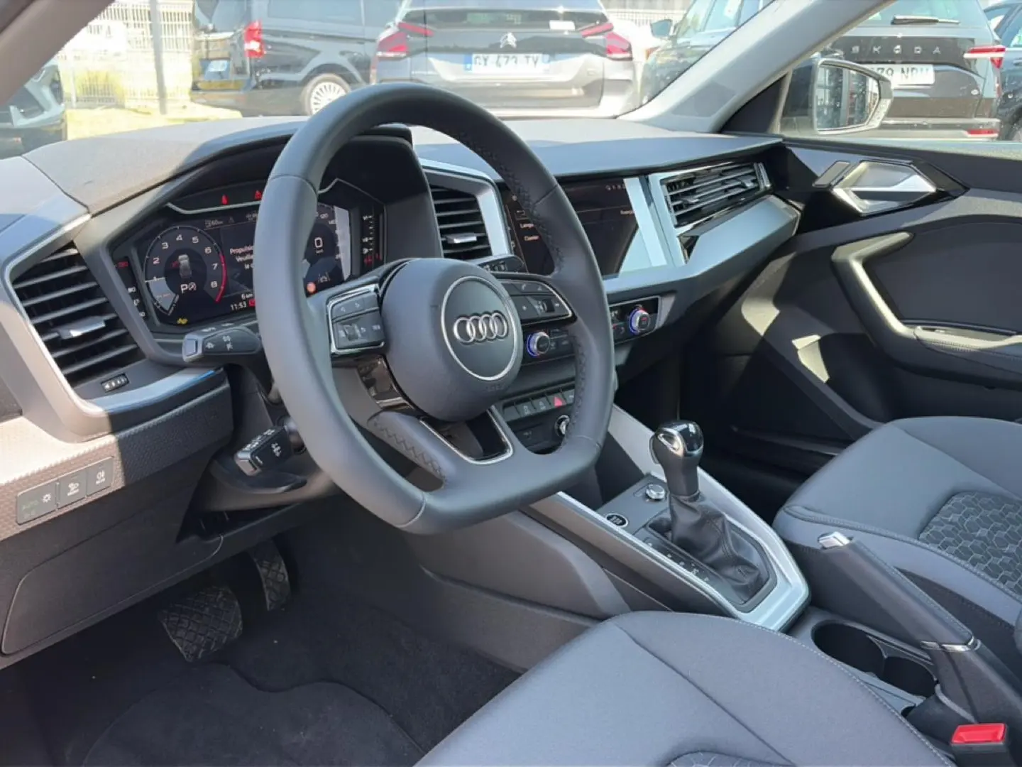 Vue intérieure côté conducteur de l'Audi A1 Sportback 2026 avec volant cuir multifonction et console centrale moderne.