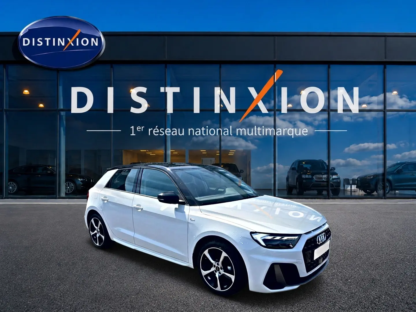 Audi A1 Sportback blanc et noir vue 3/4 avant droit devant une vitrine avec logo Distinxion.