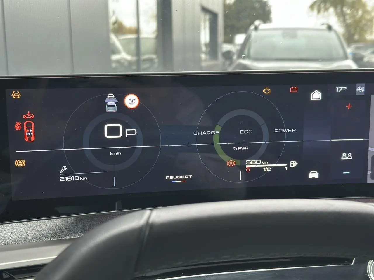 Tableau de bord numérique du Peugeot 3008 Hybrid 2024 affichant vitesse, autonomie et mode éco, vue frontale intérieure.