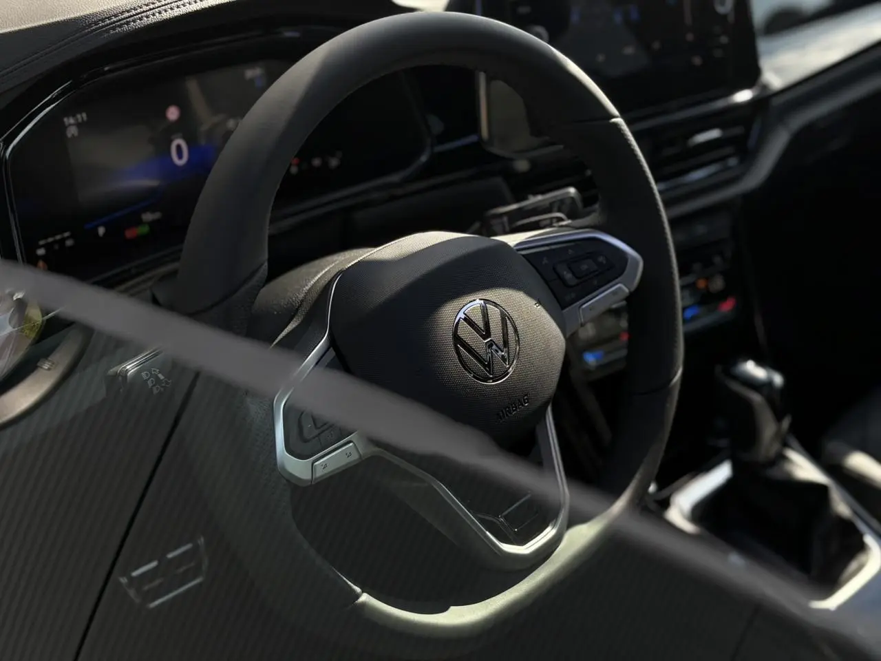 Gros plan sur le volant multifonction noir avec logo Volkswagen du tableau de bord du Volkswagen T-Roc 2025.