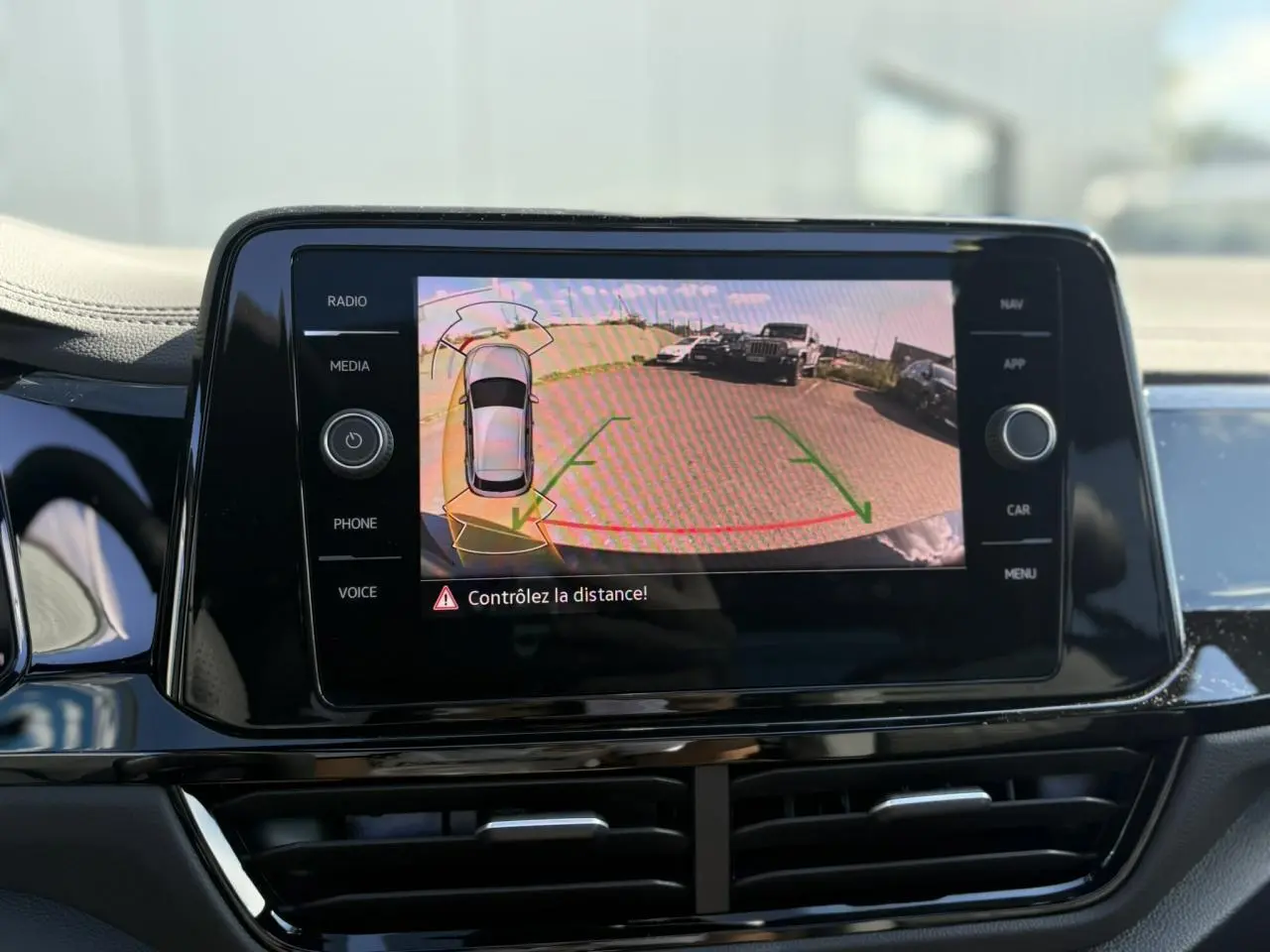 Écran tactile du système de recul affichant une vue arrière avec lignes de guidage sur Volkswagen T-Roc noir Grenadilla.