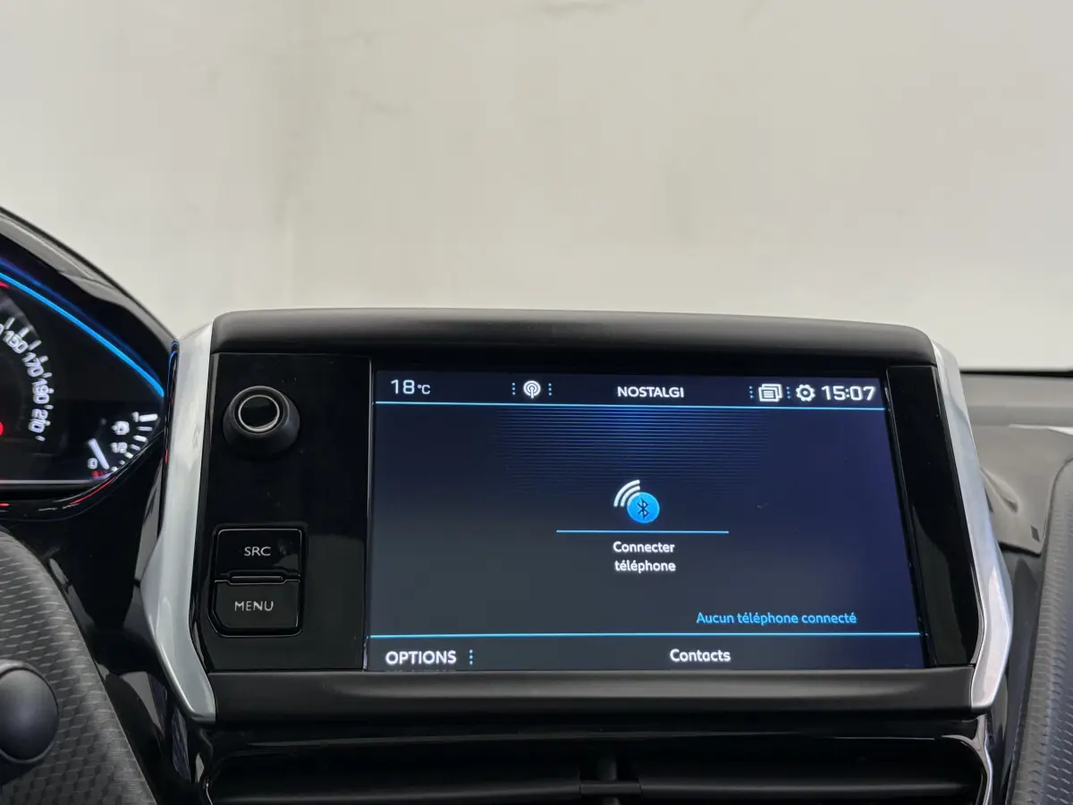 Écran tactile central du tableau de bord du Peugeot 2008 rouge, affichant la connexion Bluetooth au téléphone.