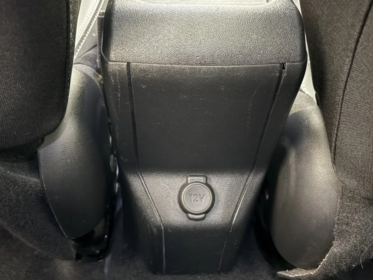 Prise 12V noire vue en gros plan entre les sièges arrière d'un Peugeot 2008 rouge version Puretech 2019.
