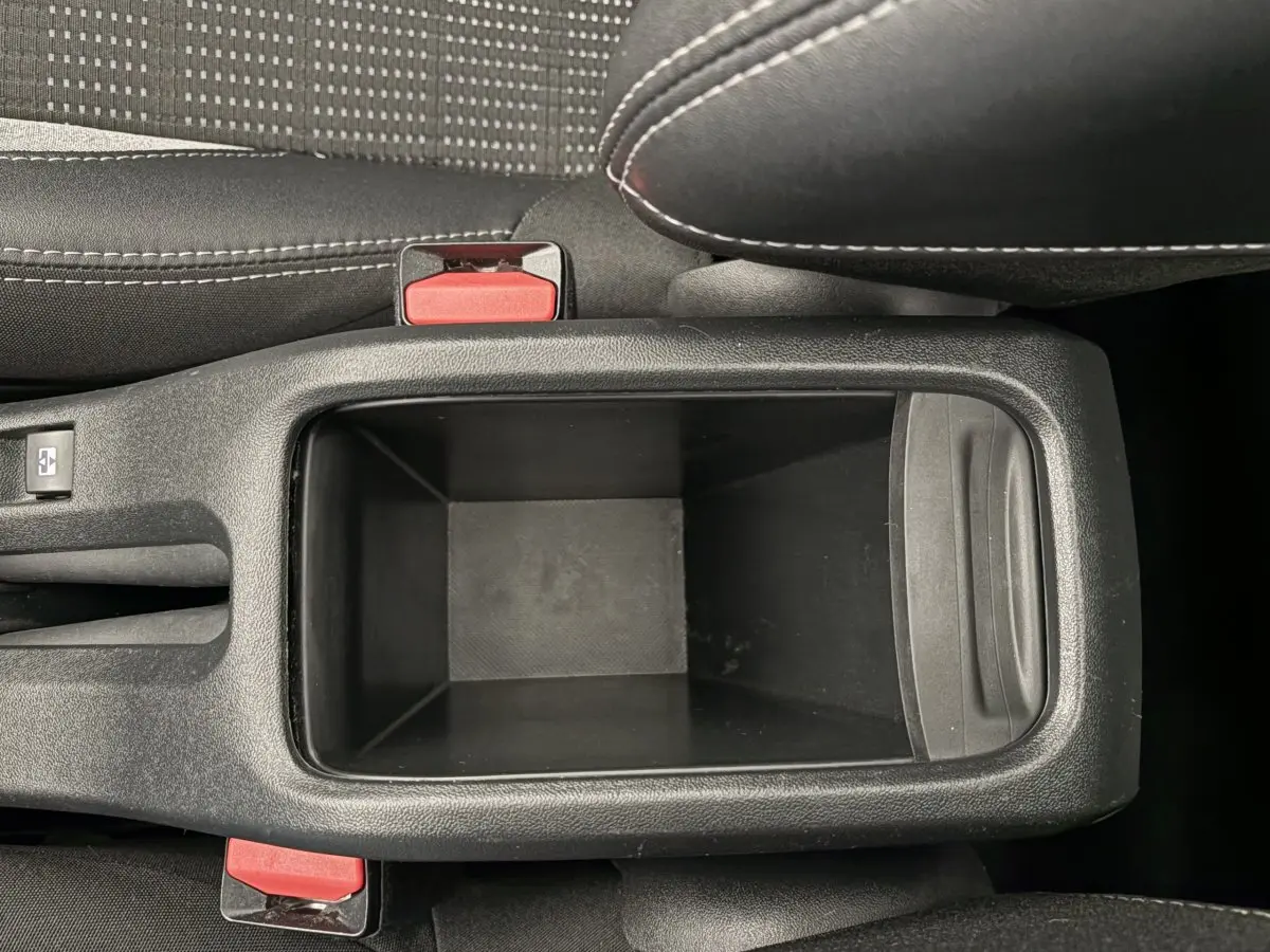 Vue plongeante sur le rangement central noir entre les sièges avant du Peugeot 2008 rouge 2019 Puretech Allure