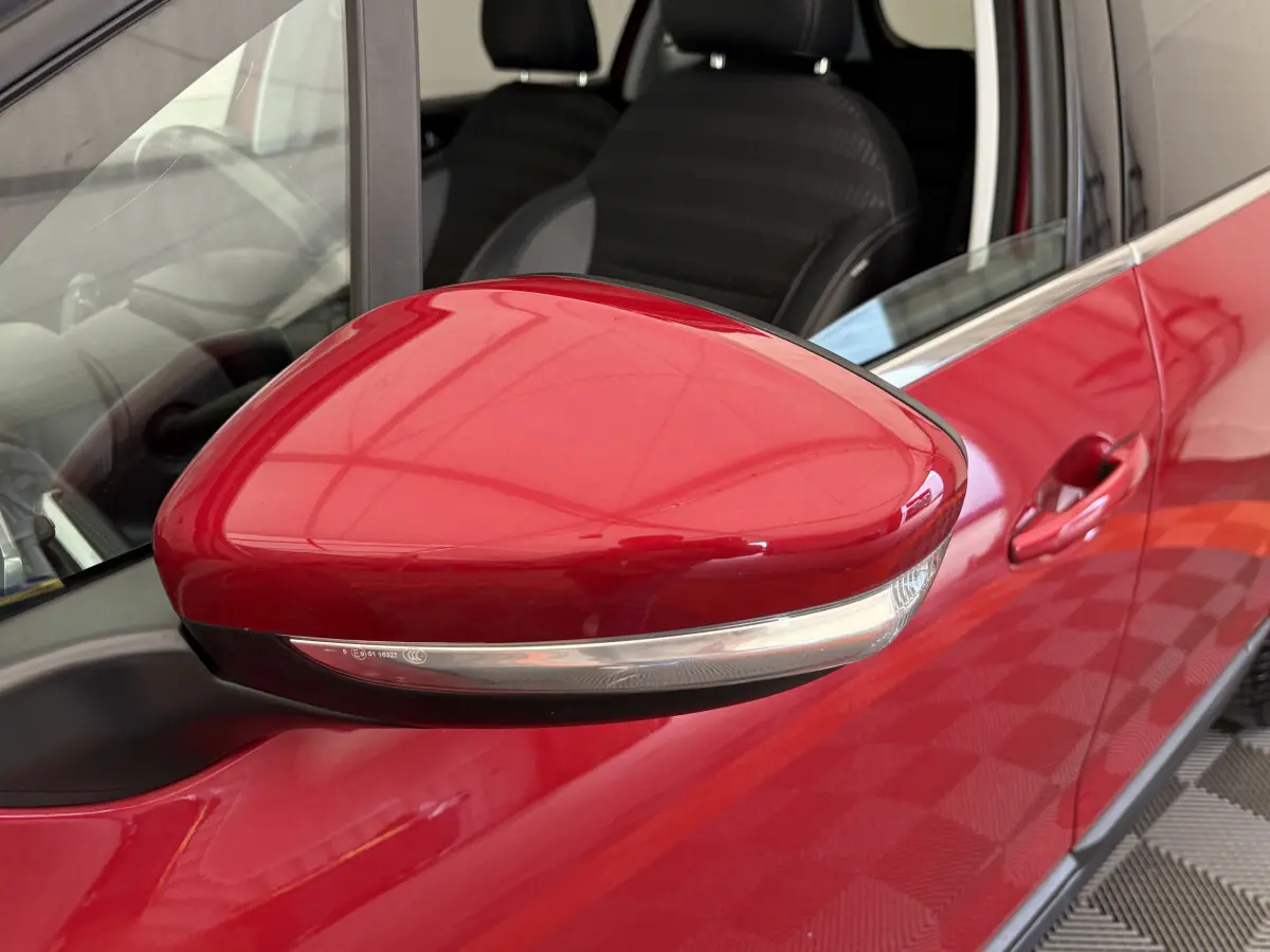 Rétroviseur côté gauche rouge brillant du Peugeot 2008 Puretech 110 S&S EAT6 Allure 2019 avec siège noir visible.