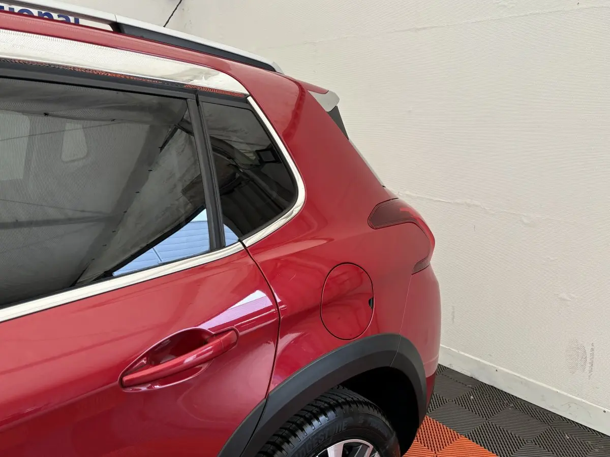 Gros plan sur l'arrière droit rouge vif du Peugeot 2008 2019 avec porte de réservoir et jante noire.