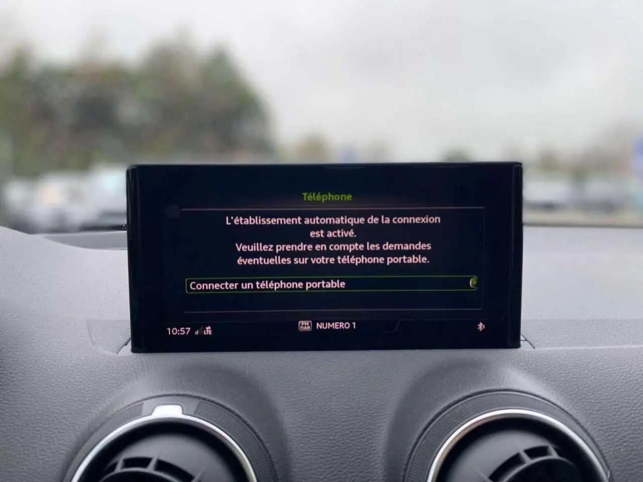 Écran central de l'Audi Q2 2023 affichant la connexion automatique d'un téléphone, avec tableau de bord gris.