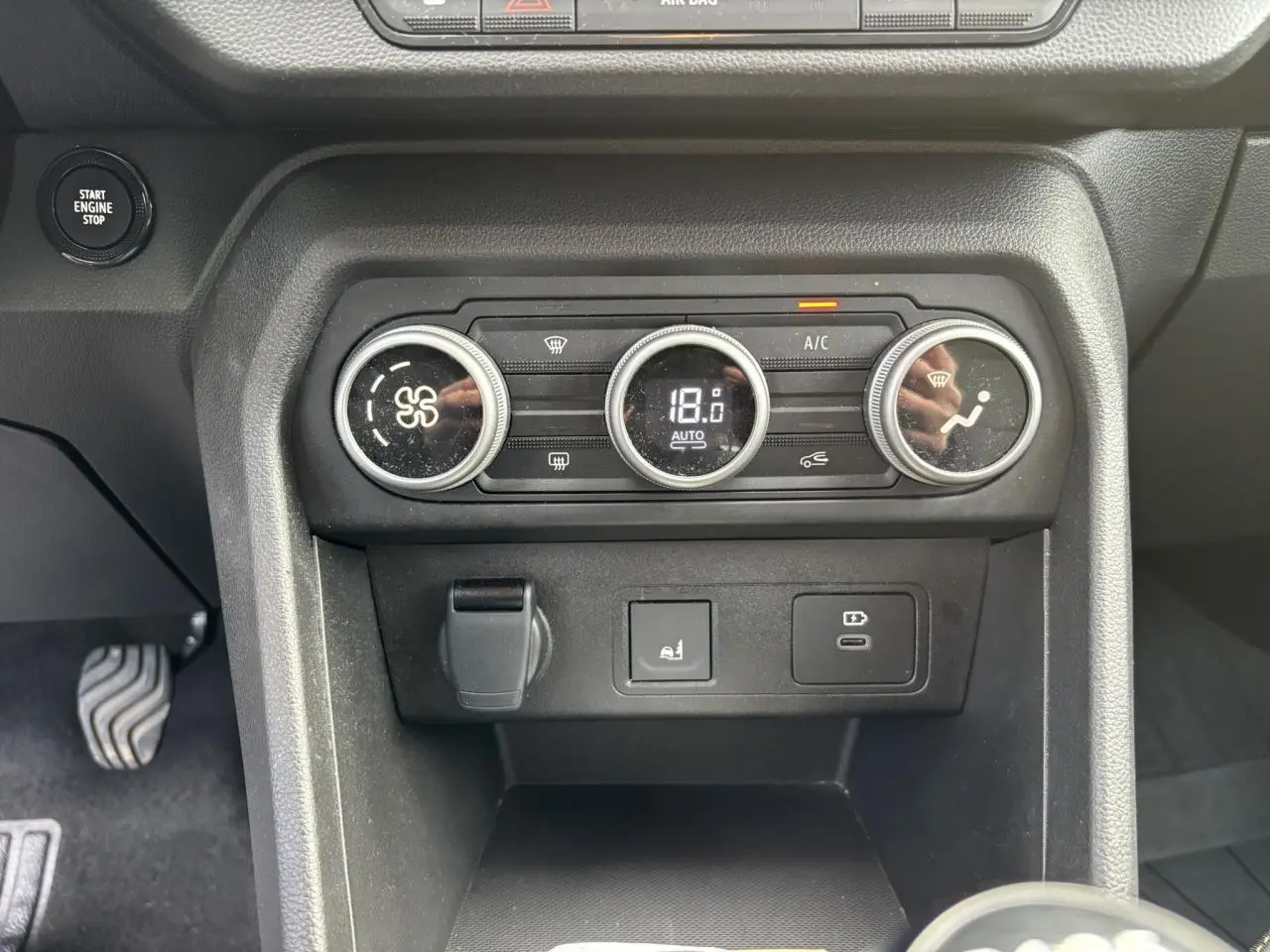 Vue rapprochée de la console centrale de la Dacia Sandero Stepway 2025, avec commandes de climatisation automatique et prises USB.