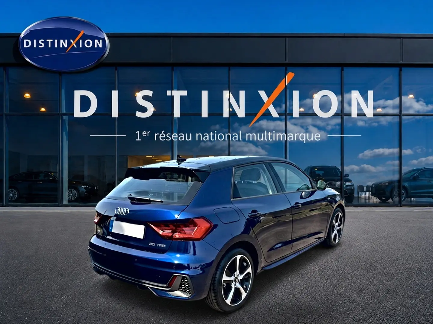 Audi A1 Sportback bleu foncé vue 3/4 arrière droit, avec jantes alu et becquet arrière sportif.