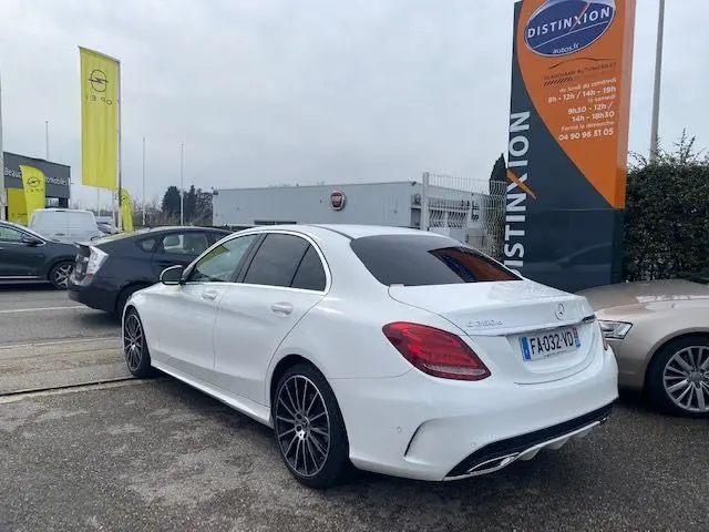 Vue 3/4 arrière droite d'une Mercedes Classe C 250D blanche de 2018 avec jantes noires et vitres teintées.