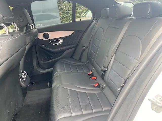 Vue intérieure côté droit des sièges arrière en cuir noir d'une Mercedes Classe C 250D 2018 avec finitions argentées sur la porte.