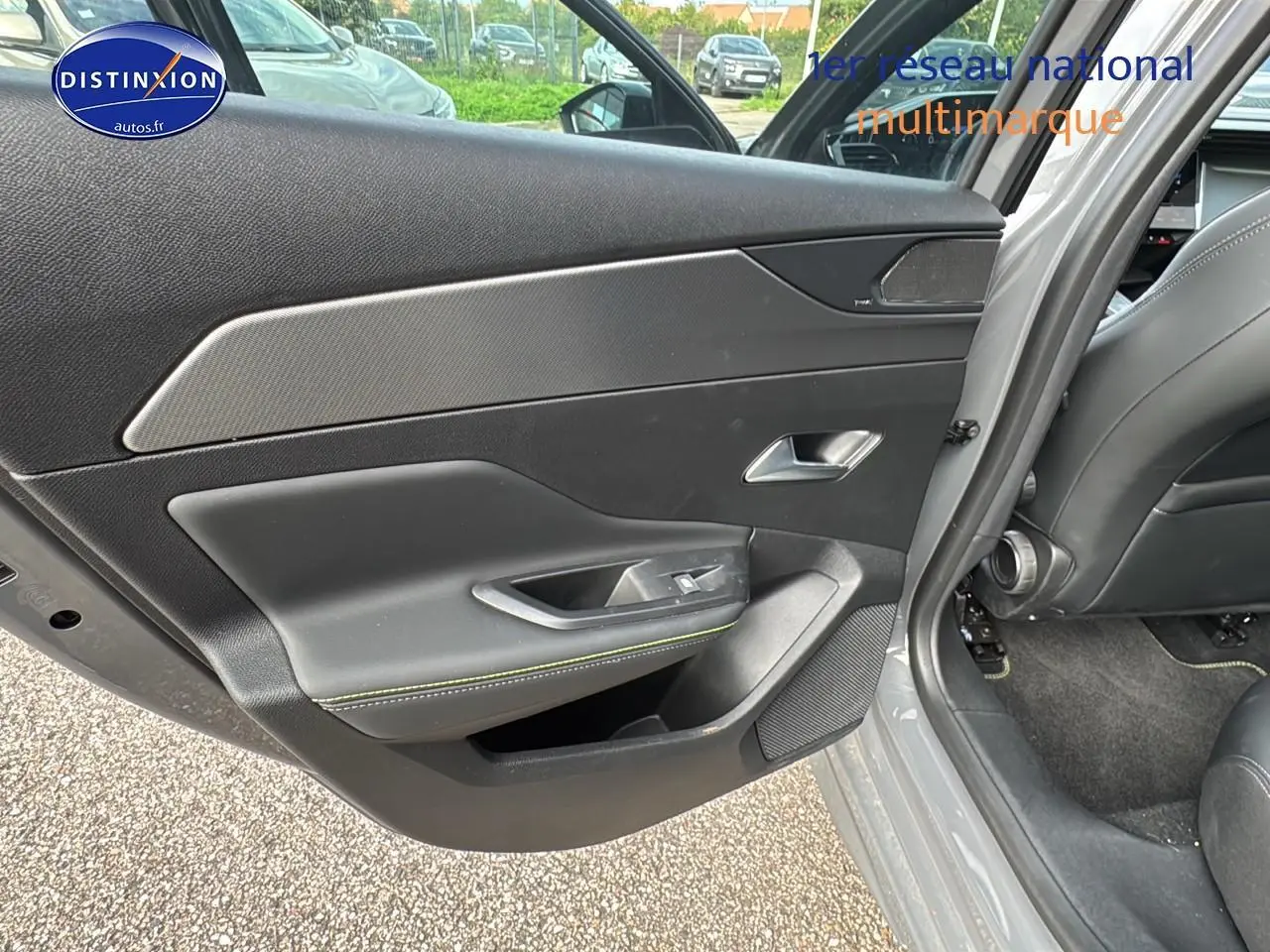 Gros plan sur la porte arrière gauche gris selenium de la Peugeot 308 SW Phev 225 GT avec garniture noire et surpiqûres vertes.