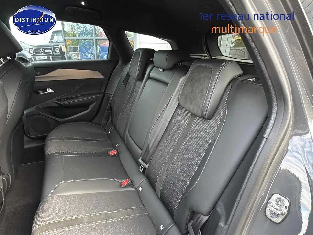 Vue intérieure côté droit montrant la banquette arrière en cuir et tissu gris d'une Peugeot 308 SW Phev 225 GT 2024.