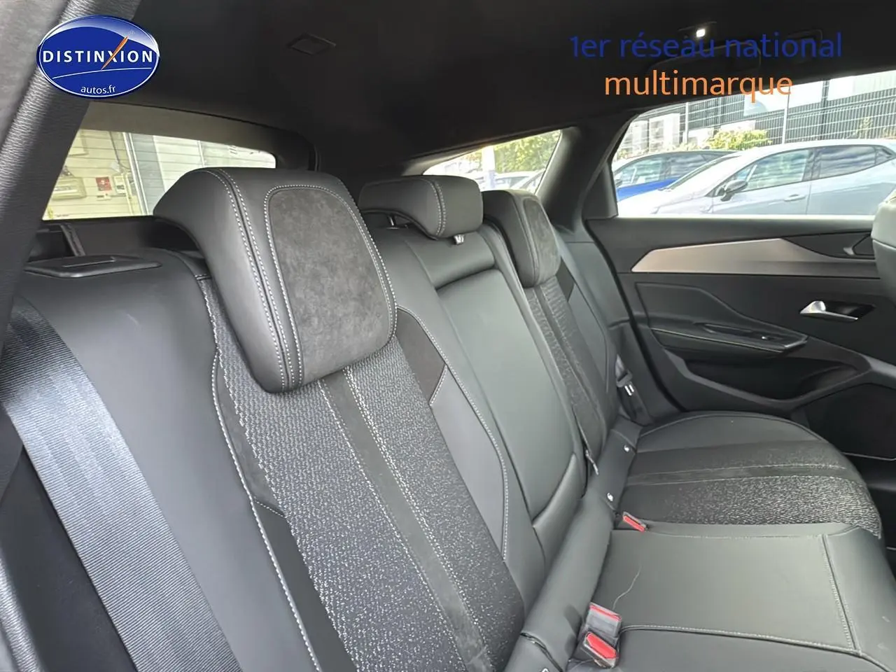 Vue intérieure sur la banquette arrière en cuir noir et tissu gris du côté droit d'une Peugeot 308 SW 2024.