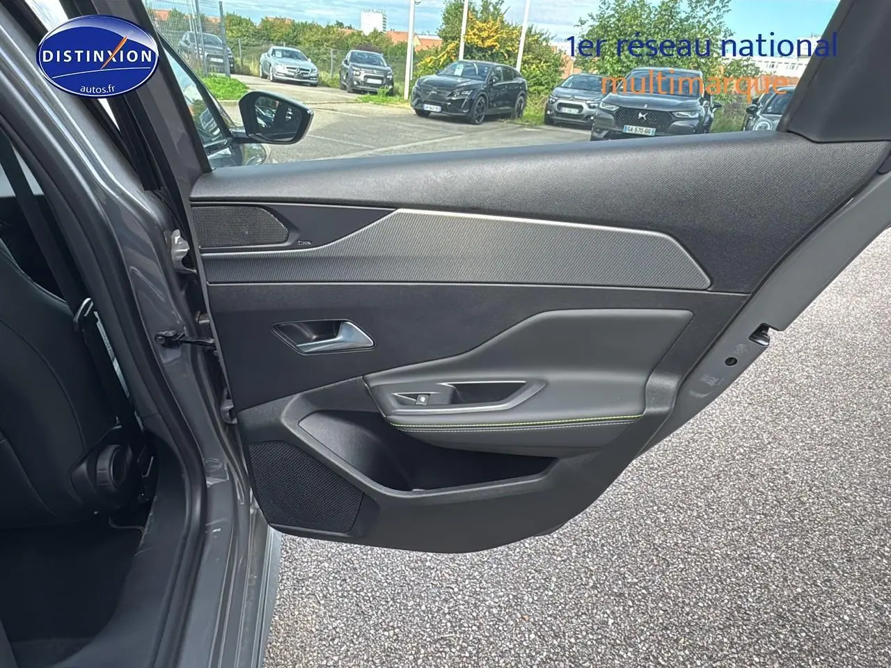 Porte arrière gauche ouverte d'une Peugeot 308 SW Phev 225 gt e-eat8 gris selenium, intérieur noir avec surpiqûres vertes.