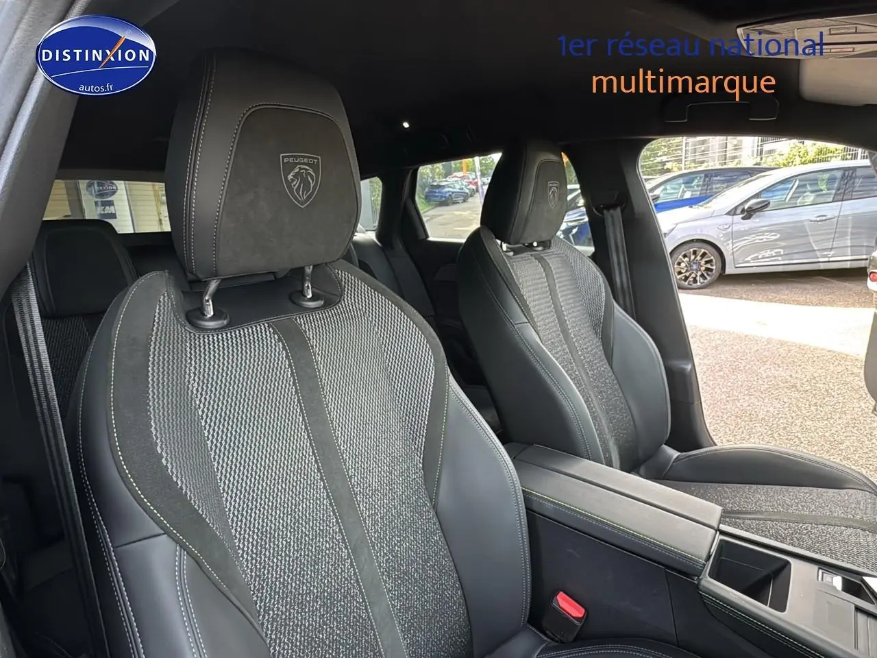 Intérieur montrant les sièges avant gris et noirs du Peugeot 308 SW Phev 225 GT e-EAT8, avec accoudoir central visible.