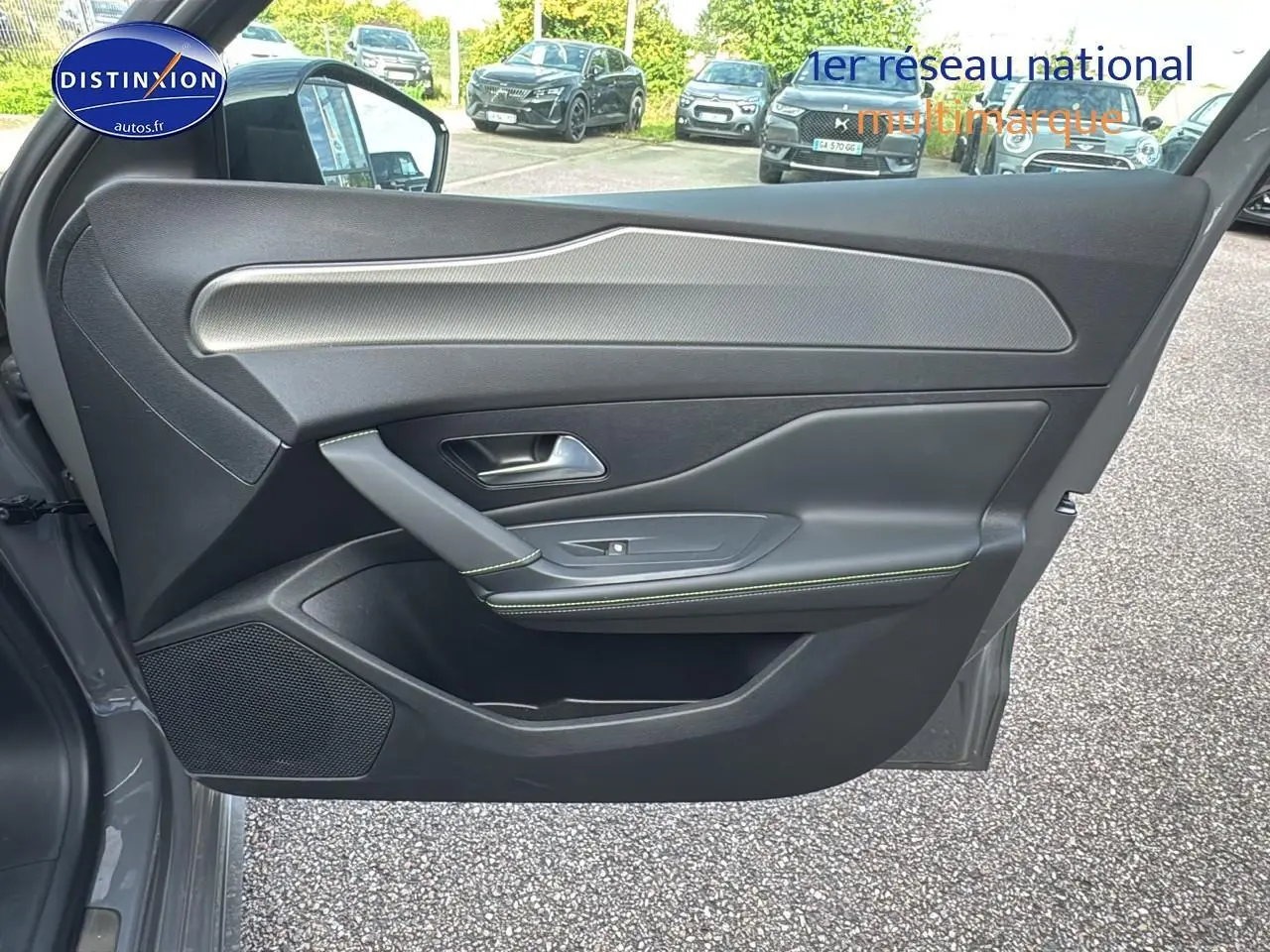 Porte côté gauche ouverte d'une Peugeot 308 SW Phev 225 GT gris selenium, intérieur noir avec surpiqûres vertes.