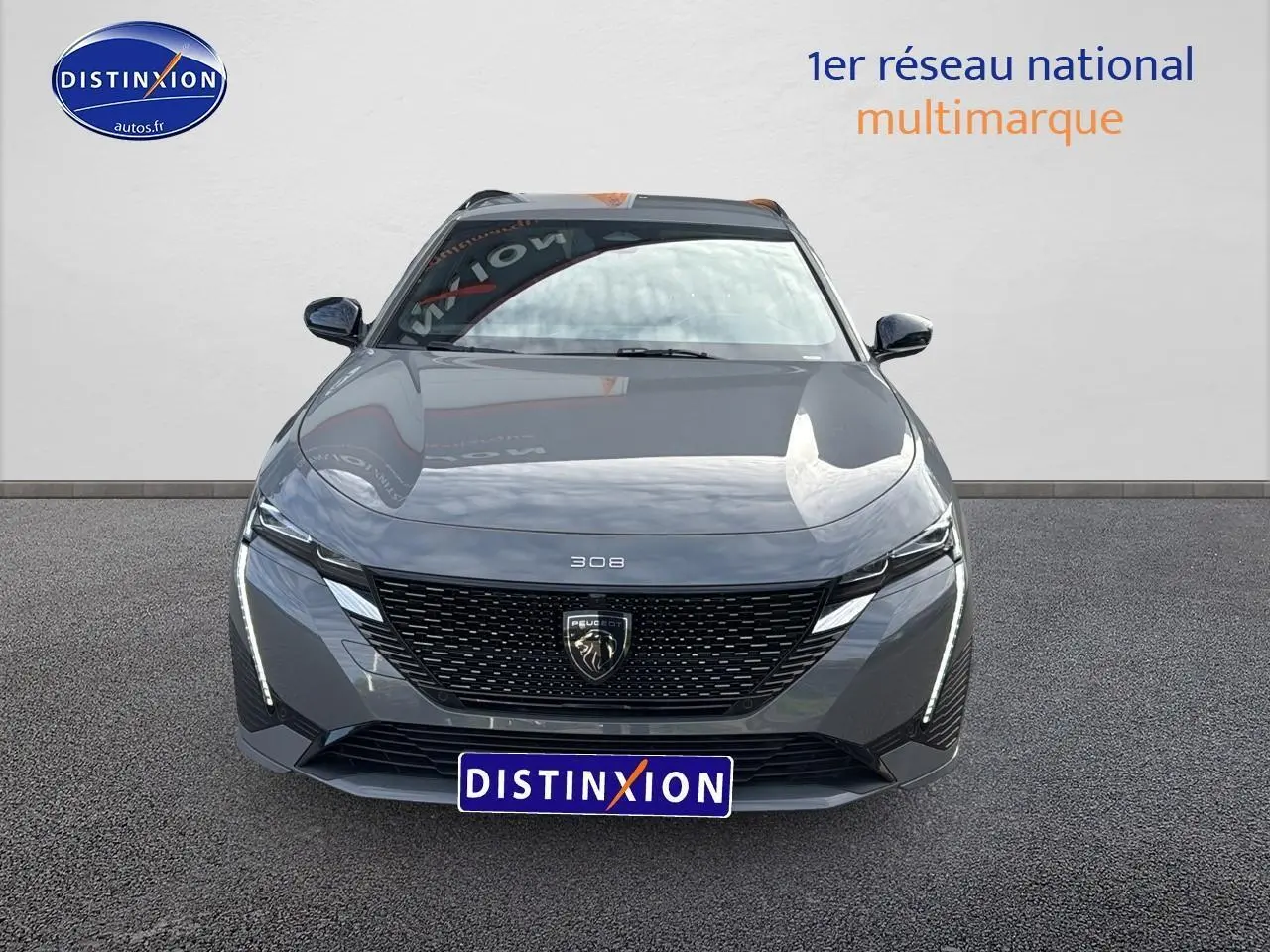 Vue frontale d'une Peugeot 308 SW Phev 225 GT gris selenium avec feux LED et calandre noire distinctive.