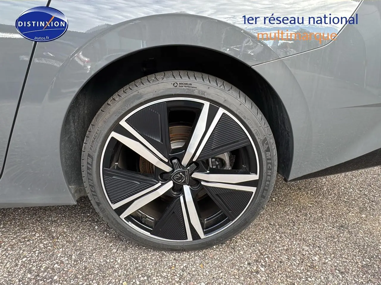 Gros plan sur la jante alu noire et argentée de la roue arrière droite d'une Peugeot 308 SW gris selenium.