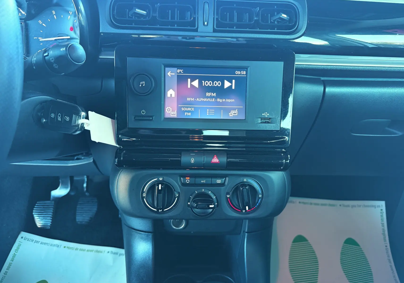 Vue rapprochée du tableau de bord noir de la Citroën C3 III avec écran tactile et commandes manuelles de climatisation.