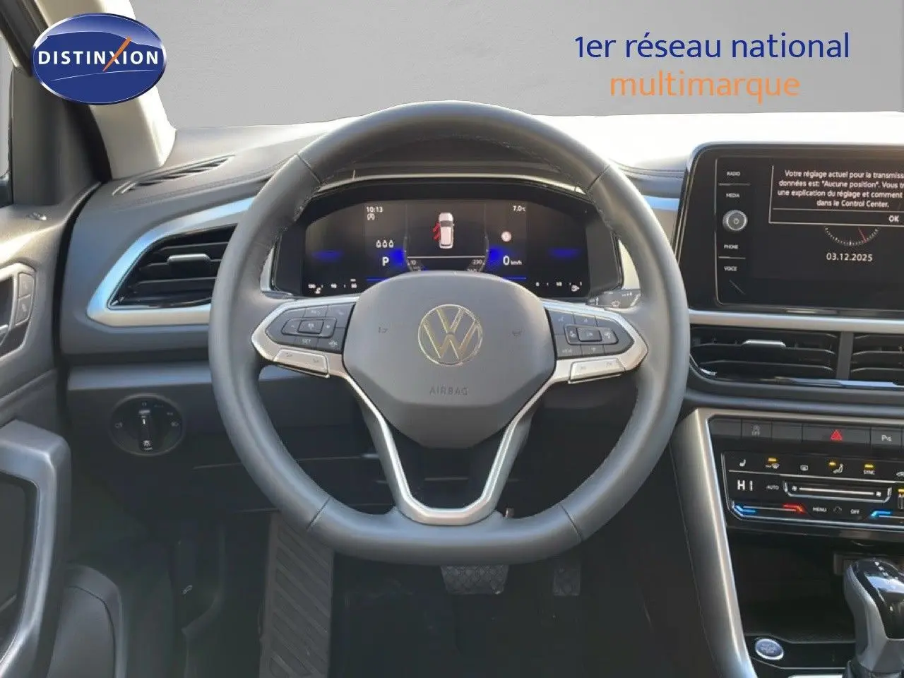 Vue intérieure centrée sur le volant du Volkswagen T-Roc 2025, tableau de bord digital et écran tactile visibles.