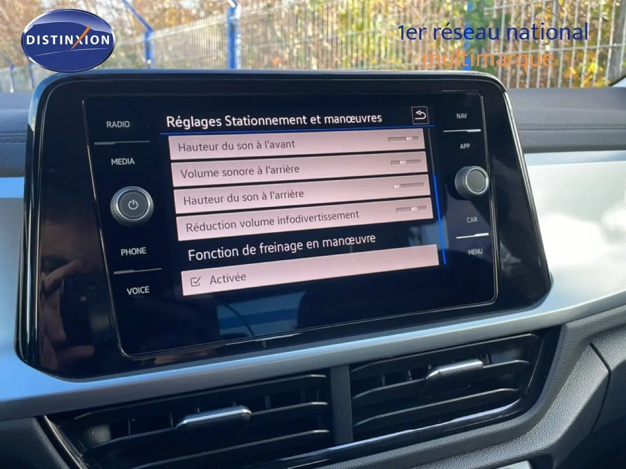 Vue rapprochée de l’écran tactile central du Volkswagen T-Roc gris pyrite, affichant les réglages de stationnement et manœuvres.