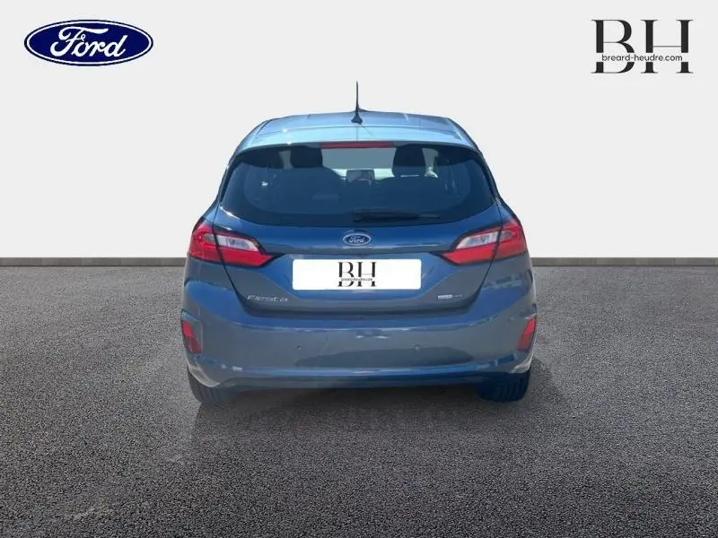 Vue arrière d'une Ford Fiesta 2022 bleu azur métallisée avec feux LED et becquet arrière.