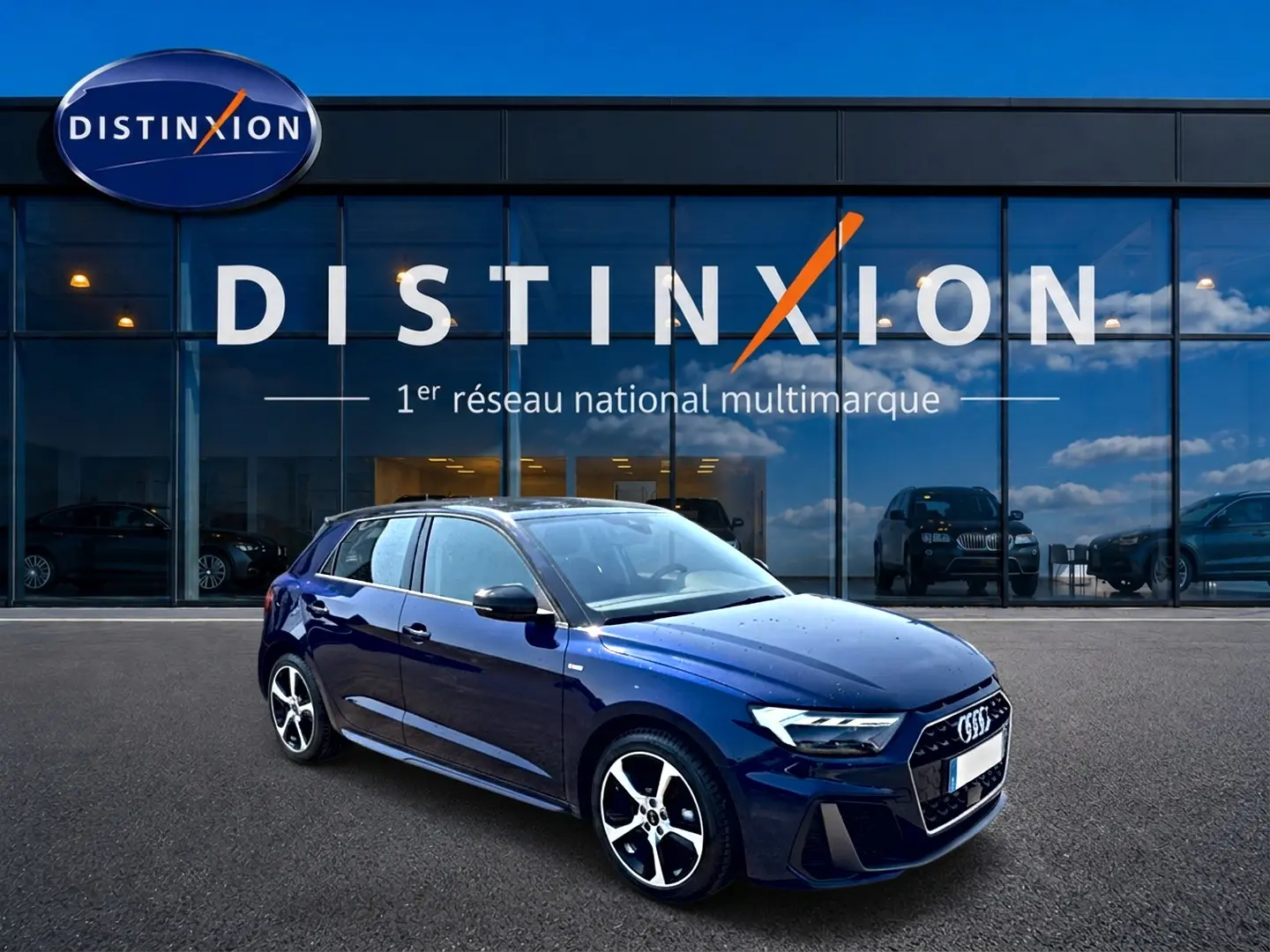 Audi A1 Sportback bleu foncé vue 3/4 avant droit, avec jantes alliage et toit noir devant showroom Distinxion.