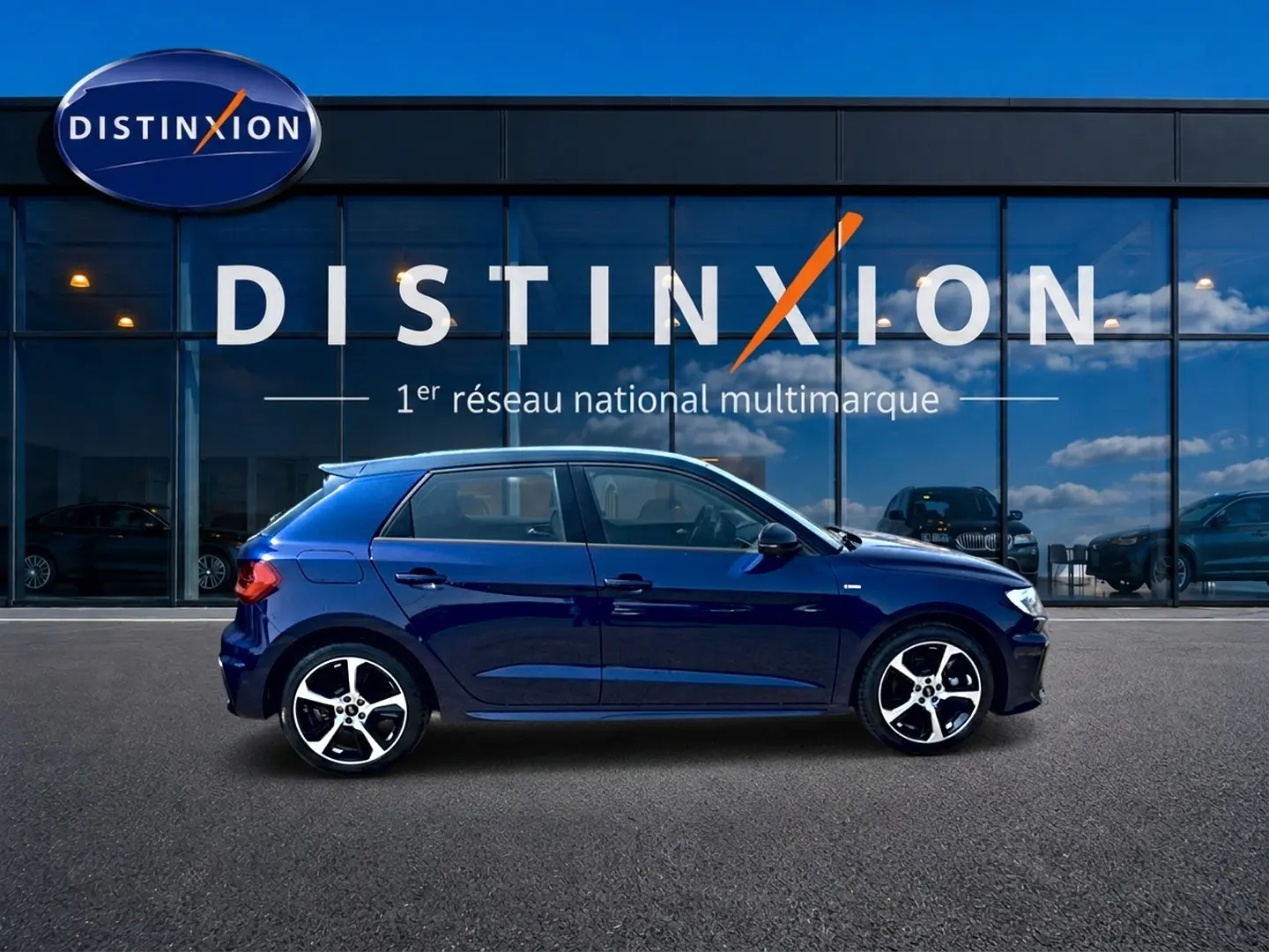 Audi A1 Sportback 30 TFSI S line bleu foncé vue de profil côté gauche devant vitrine Distinxion.