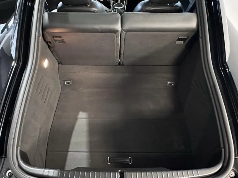 Coffre ouvert vu de dessus de l'Audi TT Coupé noir 2002, montrant l'espace de chargement et les dossiers arrière rabattus.