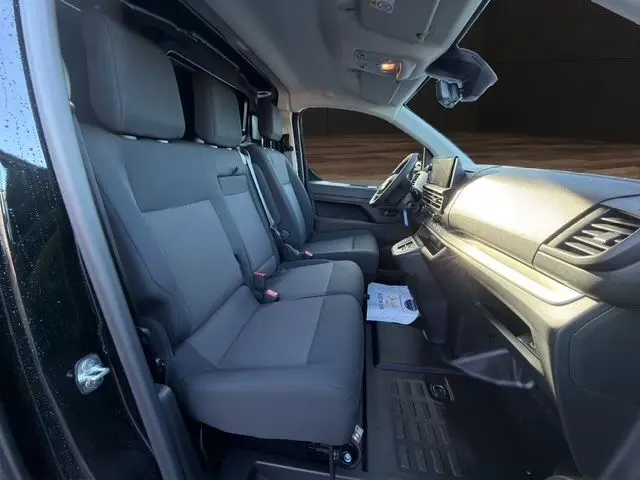 Vue intérieure côté conducteur du Peugeot Expert Fourgon noir 2025, montrant les sièges avant et le tableau de bord moderne.