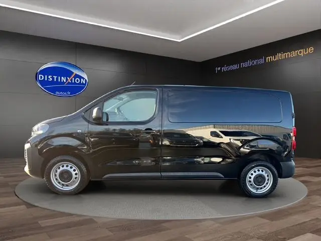 Vue de profil côté gauche du Peugeot Expert Fourgon noir 2025, dans un showroom avec logo Distinxion en arrière-plan.