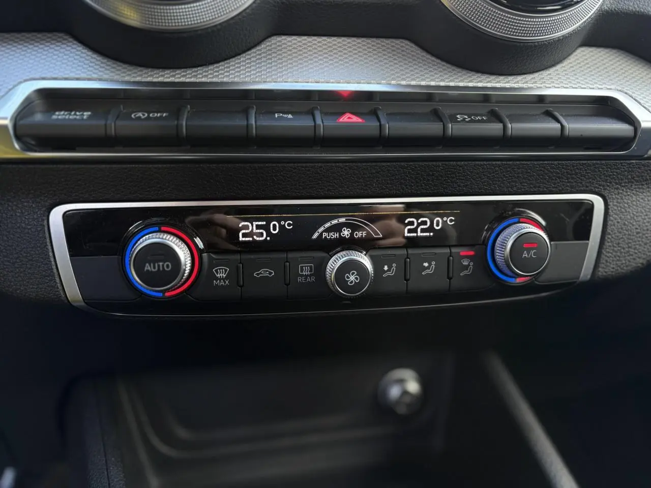 Vue rapprochée de la console centrale de l'Audi Q2 30 TDI S-Line 2025, affichant la climatisation automatique bi-zone.