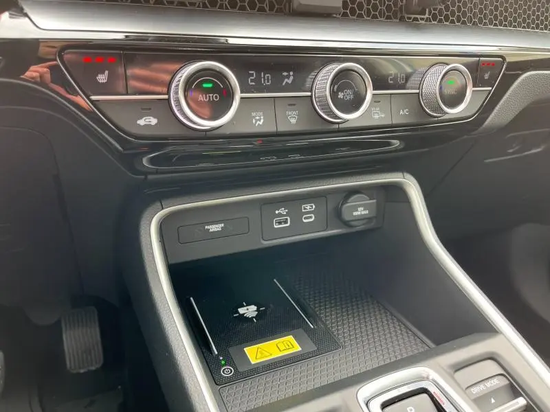Détail de la console centrale du Honda CR-V 2024 blanc platine avec commandes climatisation bi-zone et recharge sans fil.