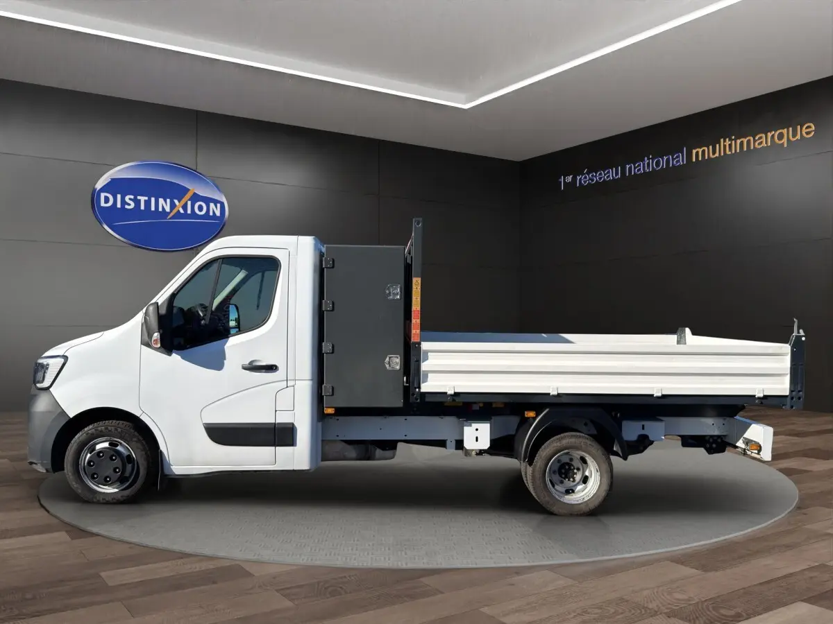 Renault Master blanc vu de profil côté gauche, avec benne arrière et coffre noir derrière la cabine.