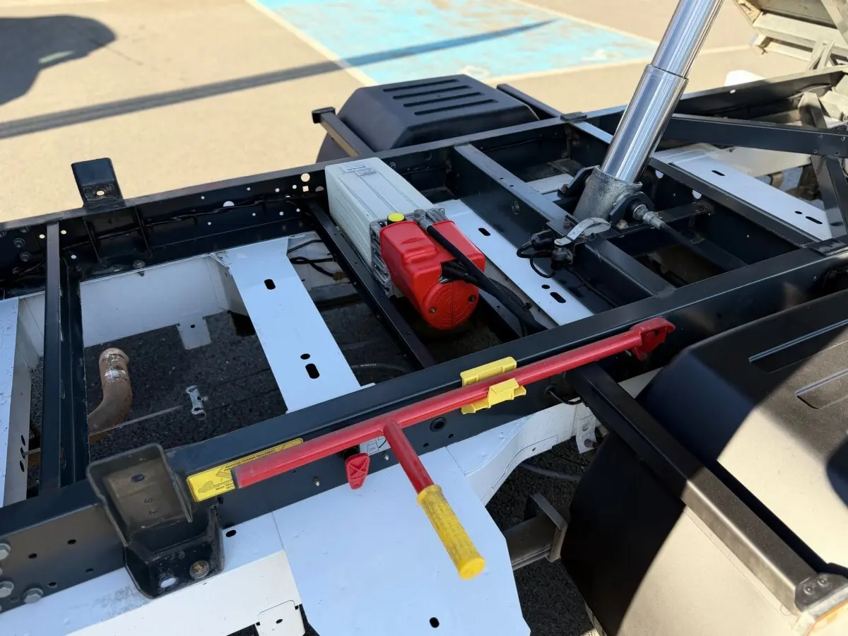 Détail du châssis arrière du Renault Master blanc 2020 avec mécanisme de benne hydraulique visible en extérieur.