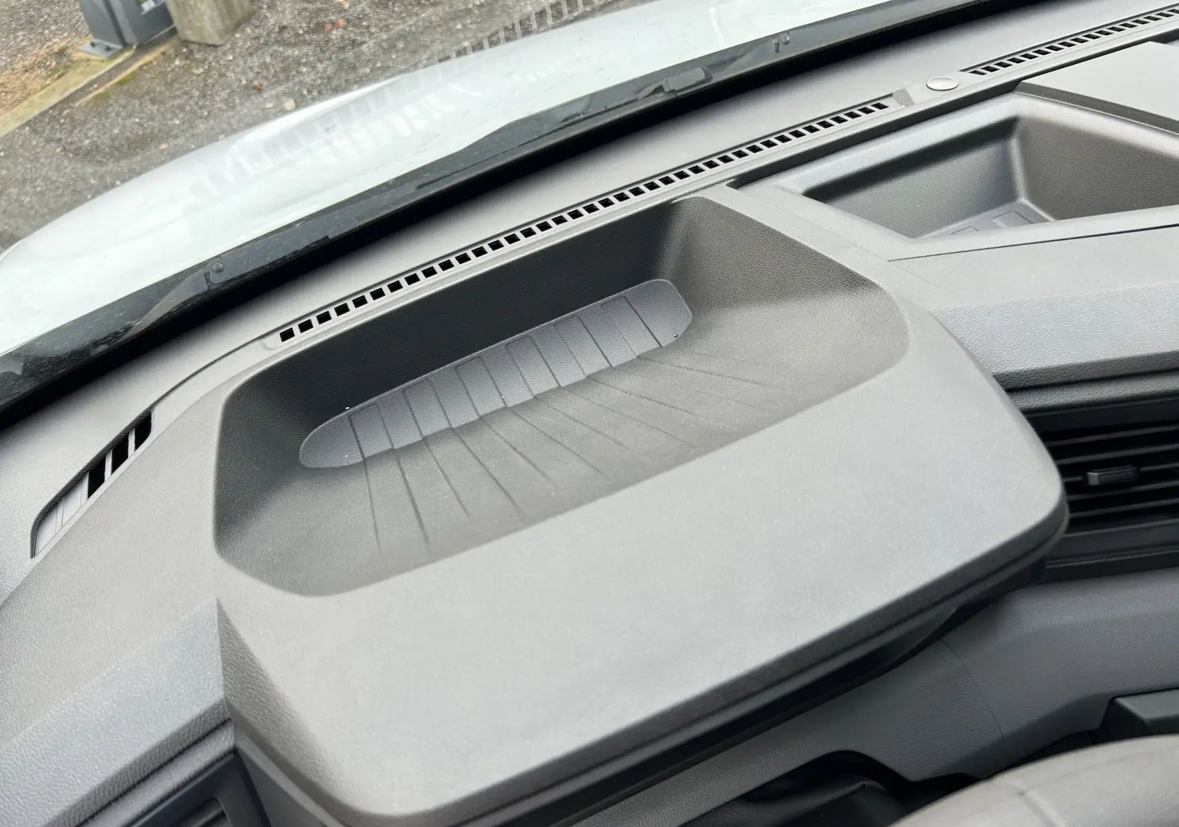 Détail du rangement intégré au tableau de bord du Renault Master blanc, vue intérieure centrée sur la console.