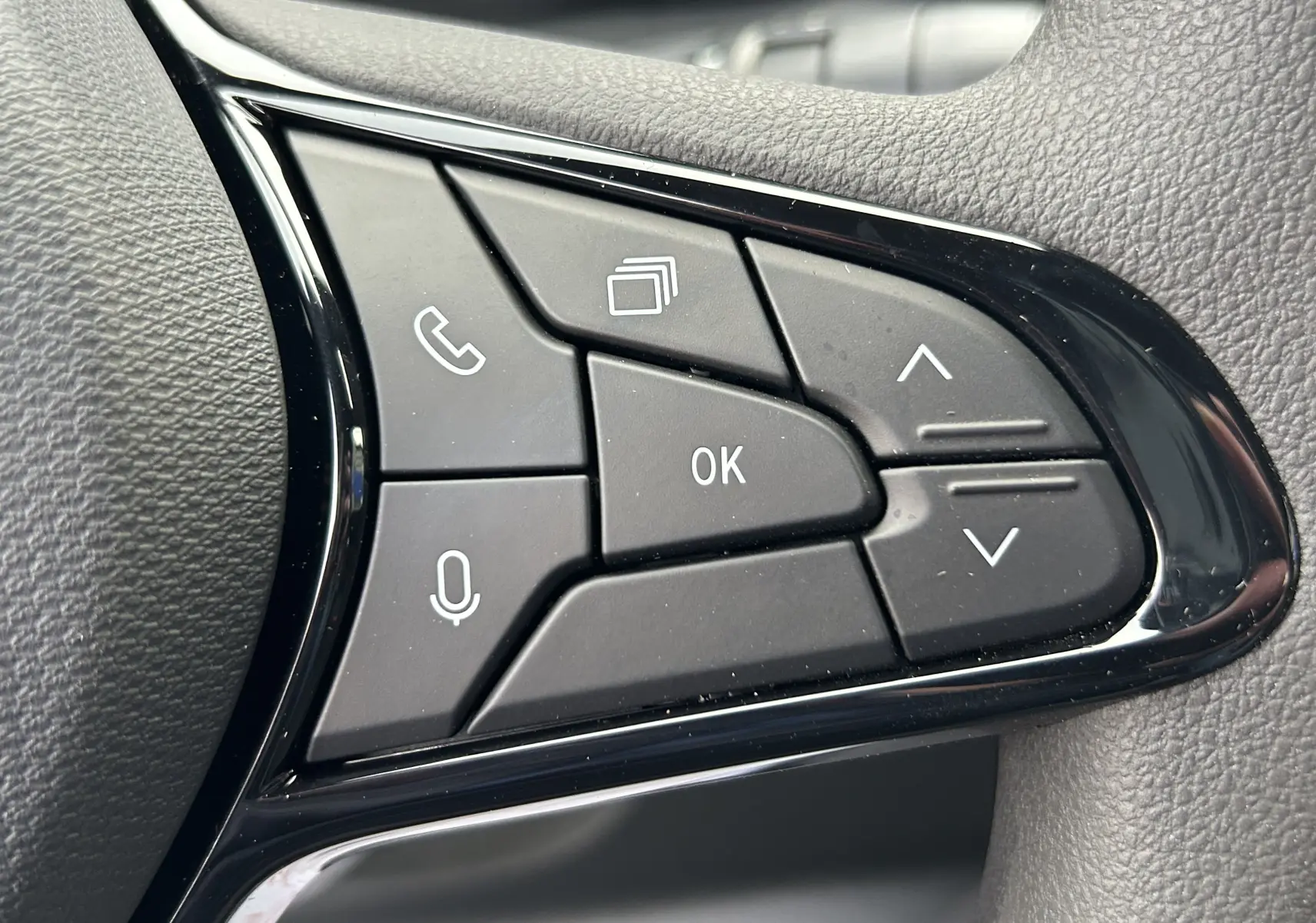 Gros plan sur les commandes multifonctions noires du volant du Renault Master, avec boutons de navigation et appel.