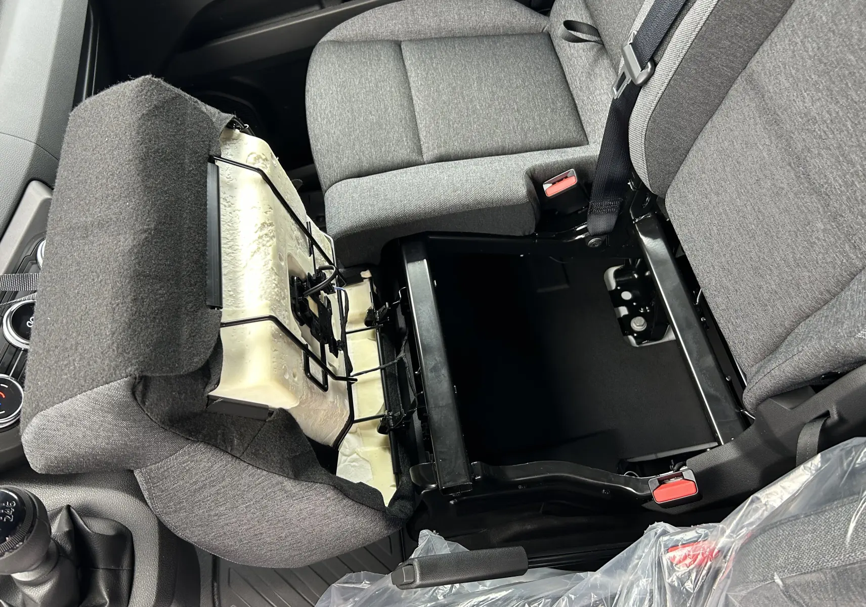 Vue intérieure rapprochée du siège passager avant relevé du Renault Master blanc, montrant le rangement sous assise en tissu gris.