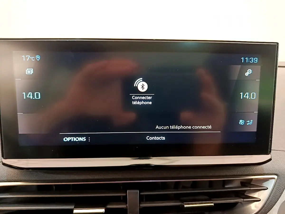 Écran tactile central du tableau de bord du Peugeot 3008 GT rouge, affichant la connexion Bluetooth téléphone.