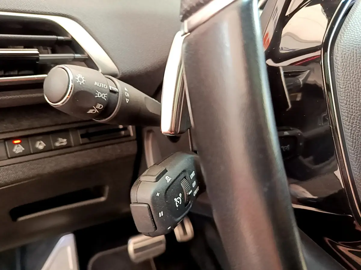 Gros plan sur la colonne de direction et commandes au volant du Peugeot 3008 GT 2021, intérieur noir.