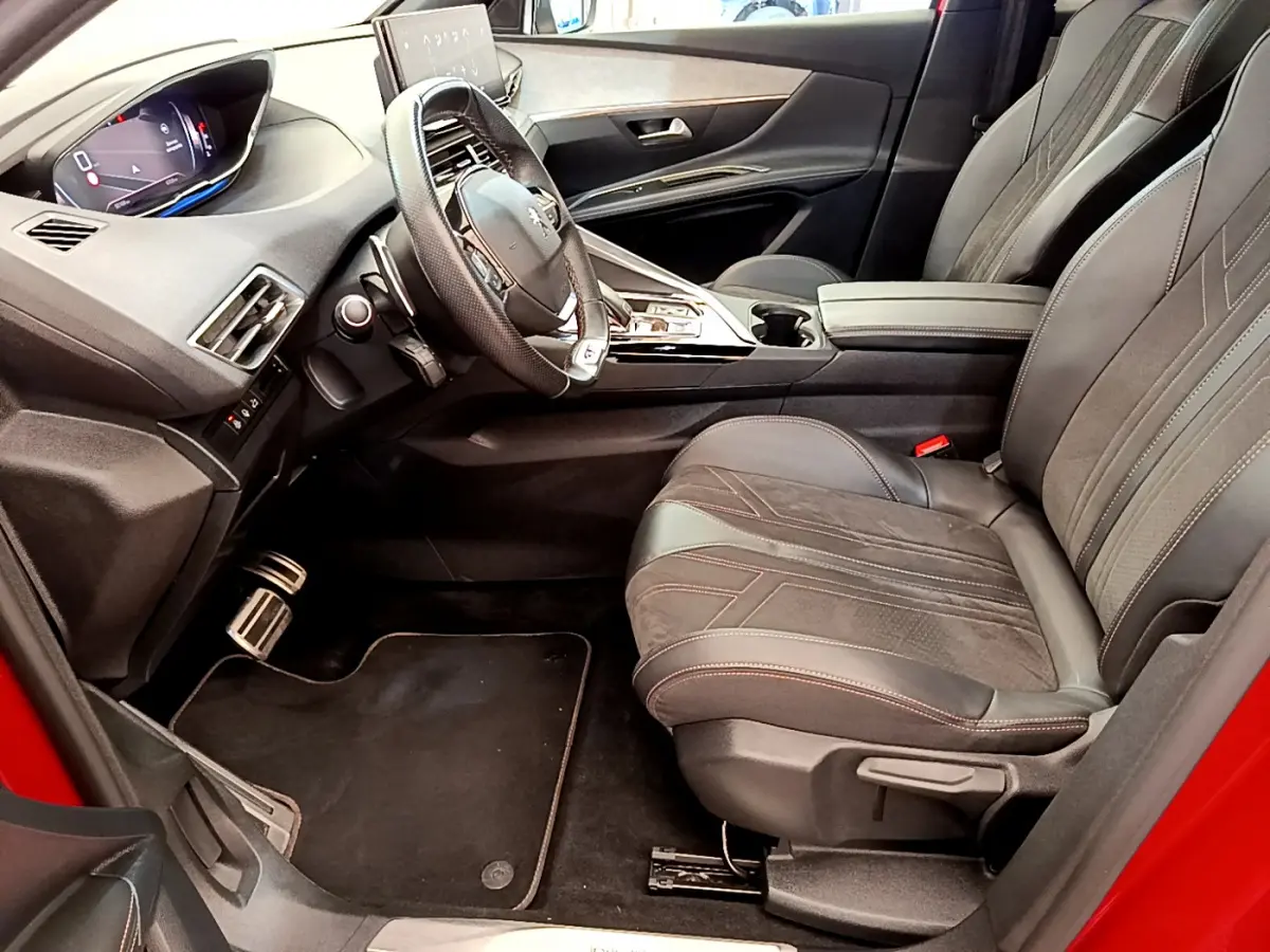 Intérieur côté conducteur du Peugeot 3008 GT rouge, avec tableau de bord numérique et sièges cuir noirs détaillés.